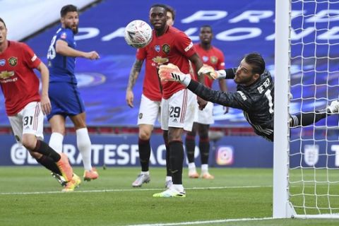 Manchester United's goalkeeper David de Gea makes a save during the English FA Cup semifinal soccer match between Chelsea and Manchester United at Wembley Stadium in London, England, Sunday, July 19, 2020. (Andy Rain, Pool via AP)