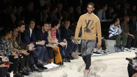 Soccer player Neymar, second from left, former soccer player David Beckham, fifth from left, and designer Victoria Beckham, sixth from left watch the Louis Vuitton men's Fall-Winter 2018/2019 fashion collection presented in Paris, Thursday, Jan.18, 2018. (AP Photo/Francois Mori)