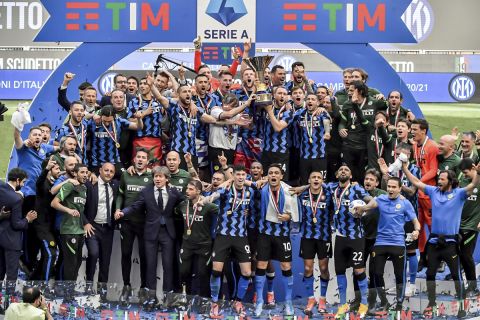 Inter Milan players celebrate with the trophy clinching the Serie A title, after the Serie A soccer match between Inter Milan and Udinese, at the San Siro stadium in Milan, Italy, Sunday, May 23, 2021. (AP Photo/Nicola Marfisi)