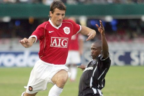 South Africa's Orlando Pirates defender Lehlohonolo Seema, right, fights for the ball with Manchester United midfielder Liam Miller, left, during the soccer Vodacom Challenge against Manchester United in Durban, South Africa, Saturday, July 15, 2006. (AP Photo/Themba Hadebe)