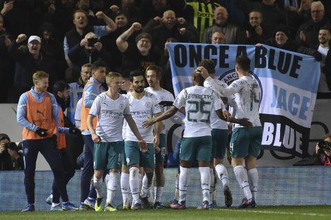 Manchester City's Jack Grealish, background center, is cheered by teammates after scoring during the English FA Cup fifth round soccer match between Peterborough United and Manchester City at the Weston Homes Stadium, Peterborough, England, Tuesday, March 1, 2022. (AP Photo/Rui Vieira)