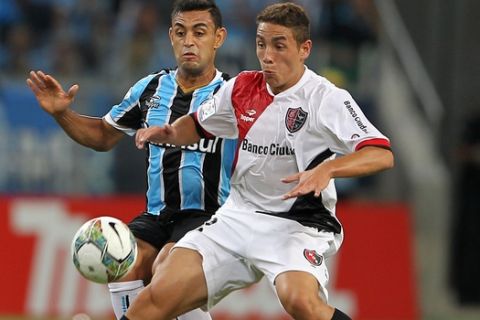 Ezequiel Ponce of Argentina's Newell's Old Boys, right, fights for the ball with Werley of Brazil's Gremio during their Copa Libertadores soccer match in Porto Alegre, Brazil, Thursday, March 13, 2014. (AP Photo/Nabor Goulart)