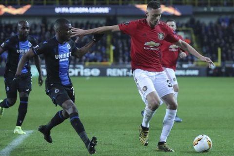 Manchester United's Nemanja Matic, right, fights for the ball with Brugge's Clinton Mata during an Europa League round of 32 first leg soccer match between Brugge and Manchester United at the Jan Breydel stadium in Bruges, Belgium, Thursday, Feb. 20, 2020. (AP Photo/Francisco Seco)