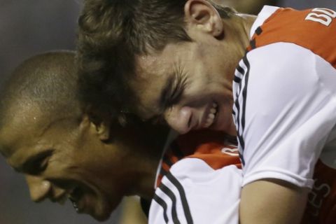 Carlos Andres Sanchez of Argentina's River Plate, left, celebrates with teammate Lucas Boye after scoring against Paraguay's Libertad during a Copa Sudamericana soccer match in Asuncion, Paraguay, Thursday, Oct. 16, 2014. (AP Photo/Jorge Saenz)
