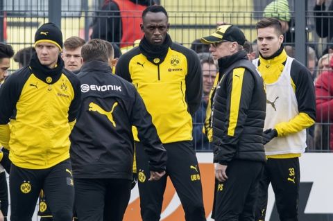 Jamaica's former sprinter Usain Bolt, third from right, takes part in a practice session of the Borussia Dortmund soccer squad in Dortmund, Germany, Friday, March 23, 2018.  Dortmund  head coach Peter Stoeger stands second right. (Guido Kirchner/dpa via AP)
