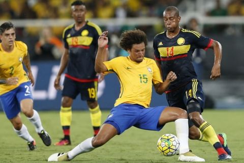 Brazil's Brazil's Willian Arao, front, fights for the ball with Colombia's Jonathan Copete, right, during a friendly soccer game at Nilton Santos stadium in Rio de Janeiro, Brazil, Wednesday, Jan 25, 2017. The match is a tribute to Chapecoense soccer players who died in a plane crash in Colombia last November. (AP Photo/Silvia Izquierdo)