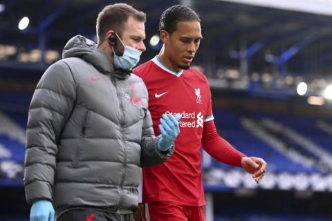 Liverpool's Virgil van Dijk leaves the match with an injury during the English Premier League soccer match between Everton and Liverpool at Goodison Park stadium, in Liverpool, England, Saturday, Oct. 17, 2020. (Laurence Griffiths/Pool via AP)
