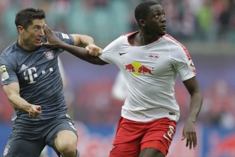 Bayern forward Robert Lewandowski, left, fights for the ball with Leipzig's Ibrahima Konate during the German Bundesliga soccer match between Leipzig and Bayern Munich at the Red Bull Arena stadium in Leipzig, Germany, Saturday, May 11, 2019. (AP Photo/Michael Probst)