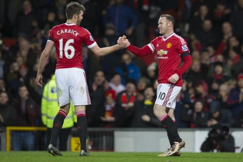 Manchester United's Wayne Rooney, right, shakes hands with teammate Michael Carrick after scoring during the English Premier League soccer match between Manchester United and Stoke at Old Trafford Stadium, Manchester, England, Tuesday, Feb. 2, 2016. (AP Photo/Jon Super)  