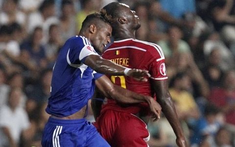 Cyprus' Dossa Junior, left, jumps for the ball with Belgium's Christian Benteke during the Euro 2016 qualifying Group B match between Cyprus and Belgium, at GSP stadium, in Nicosia, Cyprus, Sunday, Sept. 6, 2015. (AP Photo/Petros Karadjias)