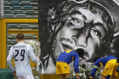 Lazio's Lorenzo De Silvestri, left, Parma's Fernando Couto and Bernardo Corradi lay bouquets of flowers next to a picture of Gabriele Sandri, the Lazio supporter who was shot to death by a police officer, prior to the kick-off of the Italian Top League soccer match beetween Lazio and Parma, at Rome's Olympic Stadium, Sunday, Nov. 25, 2007. (AP Photo/Alessandra Tarantino)