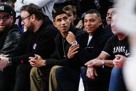 Soccer players Achraf Hakimi, center, of Morocco, and France's Kylian Mbappe look on during the second half of an NBA basketball game between the Brooklyn Nets and the San Antonio Spurs, Monday, Jan. 2, 2023, in New York. (AP Photo/Frank Franklin II)