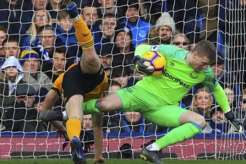 Wolverhampton Wanderers' Diogo Jota, left, clashes with Everton goalkeeper Jordan Pickford during the  English Premier League soccer match between Everton and Wolverhampton Wanderers at Goodison Park, in Liverpool, England, Saturday, Feb. 2, 2019. (Peter Byrne/PA via AP)