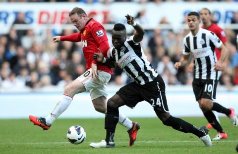 Manchester United's Wayne Rooney, left, vies for the ball Newcastle United's Cheick Tiote, centre, during their English Premier League soccer match at the Sports Direct Arena, Newcastle, England, Sunday, Oct. 7, 2012. (AP Photo/Scott Heppell)