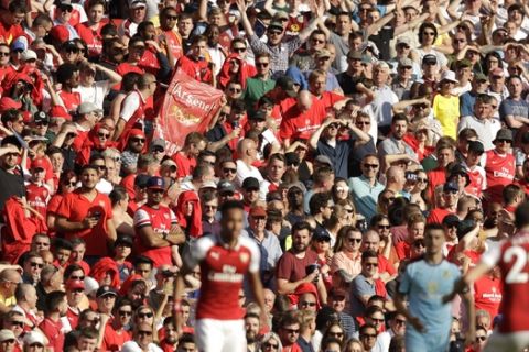 Arsenal's fans cheer after their team's third goal during the English Premier League soccer match between Arsenal and Burnley at the Emirates Stadium in London, Sunday, May 6, 2018. The match is Arsenal manager Arsene Wenger's last home game in charge after announcing in April he will stand down as Arsenal coach at the end of the season after nearly 22 years at the helm. (AP Photo/Matt Dunham)