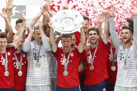 Bayern's Thomas Mueller, center, lifts the trophy after the German Soccer Bundesliga match between FC Bayern Munich and VfB Stuttgart in Munich, Germany, Saturday, May 12, 2018. (AP Photo/Matthias Schrader)