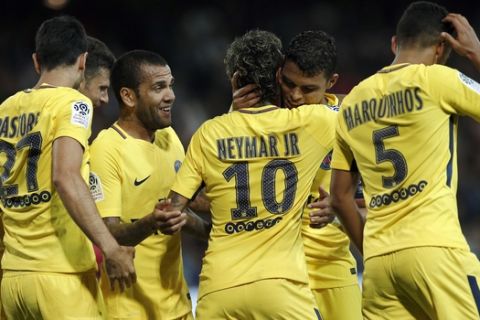 PSG's Neymar, center right back to camera, is congratulated by teammates Dani Alves after scoring his side's 3rd goal during the French League One soccer match between Guingamp and PSG at the Roudourou stadium in Guingamp, western France, Sunday, Aug. 13, 2017. Neymar makes his long-awaited debut with Paris Saint-Germain on Sunday in the small Brittany town of Guingamp. (AP Photo/Kamil Zihnioglu)