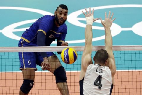 France's Earvin Ngapeth, left, spikes the ball past United States' David Lee during a men's preliminary volleyball match at the 2016 Summer Olympics in Rio de Janeiro, Brazil, Saturday, Aug. 13, 2016. (AP Photo/Matt Rourke)