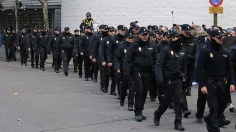 Police officers walk to take position outside Real Madrid's Santiago Bernabeu stadium in Madrid, Spain, Saturday, Nov. 21, 2015.  Unprecedented security measures are in place for the first clasico of the season between Real Madrid and Barcelona, with nearly 3,000 policemen and private security officers dispatched to guarantee public safety at the Santiago Bernabeu stadium in Madrid. (AP Photo/Paul White)