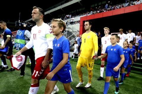 Denmark's captain Christian Offenberg leads his team to the pitch prior a friendly soccer match between Slovakia and Denmark in Trnava, Slovakia, Wednesday, Sept. 5, 2018. Every player in Denmark's squad are uncapped following a dispute between Denmark's star players and the Danish Football Association. (AP Photo/Ronald Zak)