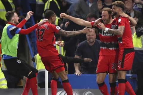 Huddersfield Town's Laurent Depoitre, second right, celebrates scoring against Chelsea with teammates during the English Premier League soccer match at Stamford Bridge, London, Wednesday May 9, 2018. (John Walton/PA via AP)