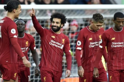 Liverpool's Mohamed Salah, 3rd left, celebrates with teammates after scoring his sides first goal during the English Premier League soccer match between Liverpool and Watford at Anfield stadium in Liverpool, England, Saturday, Dec. 14, 2019. (AP Photo/Rui Vieira)