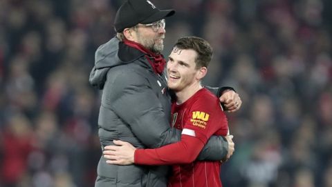 Liverpool's manager Jurgen Klopp embraces Liverpool's Andrew Robertson at the end of the English Premier League soccer match between Liverpool and Wolverhampton Wanderers at Anfield Stadium, Liverpool, England, Sunday Dec. 29, 2019. Liverpool won 1-0. (AP Photo/Jon Super)