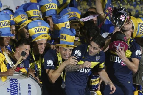 Boca Juniors' Pablo Perez kisses the trophy after his team won the national soccer tournament in Buenos Aires, Argentina, Sunday, June 25, 2017. Boca Juniors defeated Union de Santa Fe 2-1. (AP Photo/Agustin Marcarian).