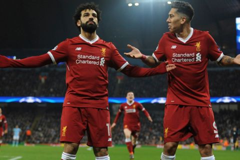 Liverpool's Mohamed Salah, left, celebrates scoring his side's first goal with Liverpool's Roberto Firmino during the Champions League quarterfinal second leg soccer match between Manchester City and Liverpool at Etihad stadium in Manchester, England, Tuesday, April 10, 2018. (AP Photo/Rui Vieira)