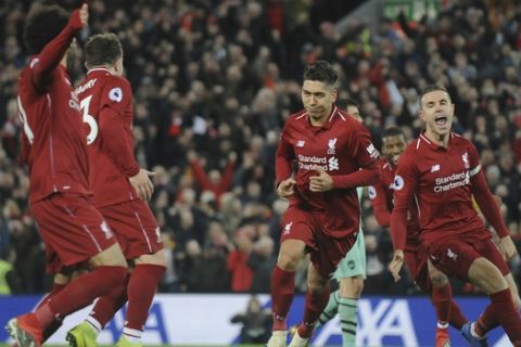 Liverpool's Roberto Firmino, second right, celebrates after he scores his sides 5th goal and his 3rd from the penalty spot during the English Premier League soccer match between Liverpool and Arsenal at Anfield in Liverpool, England, Saturday, Dec. 29, 2018. (AP Photo/Rui Vieira)