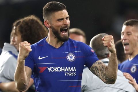 Chelsea's Oliver Giroud clenches his fists as other Chelsea players hug goalkeeper Kept Arrizabalaga, right, who made two saves in the penalty shootout during the Europa League semifinal second leg soccer match between FC Chelsea and Eintracht Frankfurt at Stamford Bridge stadium in London, Thursday, May 9, 2019. Chelsea won the shootout and will play the final. (AP Photo/Alastair Grant)