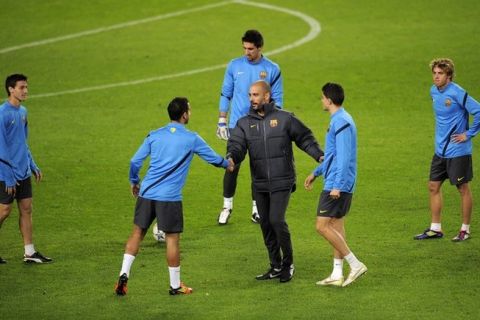 Barcelona's coach Josep Guardiola (C) greets Barcelona's young players during a training session at the Camp Nou stadium in Barcelona, December 5, 2011 on the eve of their UEFA Champions League football match against Bate Borissov.    AFP PHOTO/ LLUIS GENE (Photo credit should read LLUIS GENE/AFP/Getty Images)