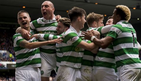 Celtic's Callum McGregor celebrates with teammates after scoring his sides' third goal of the game during their Scottish Premiership soccer match against Rangers at the Ibrox Stadium, Glasgow, Scotland, Saturday, April 29, 2017. Celtic dished out one last humiliation to hapless Rangers as their 5-1 win at Ibrox took them to within five games of an unbeaten domestic campaign. The Parkhead faithful lapped up every moment of this season's sixth and final Old Firm duel as Brendan Rodgers' undefeated troops outclassed a feeble Rangers line-up from start to finish. (Craig Watson/PA via AP)