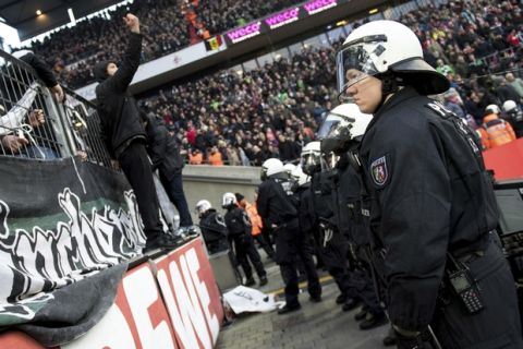 Police watches a group of Cologne's fans, trying to get on the pitch, during half time of the German Bundesliga soccer match between 1. FC Cologne and Borussia Moenchengladbach  at the Rhine Energy Stadium in Cologne, Germany, Sunday, Jan. 14, 2018. (Marius Becker/dpa via AP)