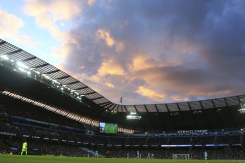 The sun sets behind the stadium during the English Premier League soccer match between Manchester City and Manchester United at the Etihad Stadium in Manchester, Thursday, April 27, 2017.(AP Photo/Dave Thompson)