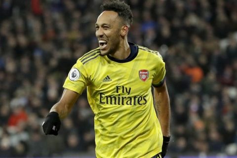 Arsenal's Pierre-Emerick Aubameyang celebrates after scoring his side's third goal duels for the ball with during the English Premier League soccer match between West Ham Utd and Arsenal at the London Stadium in London, Monday, Dec. 9, 2019. (AP Photo/Kirsty Wigglesworth)