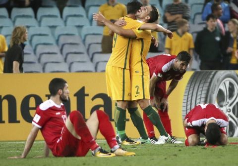 Australia's Tomi Juric, center left, and Milos Degenek celebrates their win over Syria in their Soccer World Cup qualifying match in Sydney, Australia, Tuesday, Oct. 10, 2017. (AP Photo/Rick Rycroft)