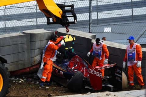 SOCHI, RUSSIA - OCTOBER 10:  Course marshalls remove Carlos Sainz of Spain and Scuderia Toro Rosso's damaged car after he crashed during final practice for the Formula One Grand Prix of Russia at Sochi Autodrom on October 10, 2015 in Sochi, Russia.  (Photo by Lars Baron/Getty Images)