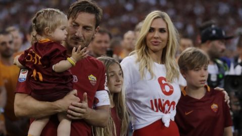 Roma's Francesco Totti holds her daughter Isabel, with the other daughter Chanel, his wife Ilary and his son Cristian walking next to him as he salutes his fans after an Italian Serie A soccer match between Roma and Genoa at the Olympic stadium in Rome, Sunday, May 28, 2017. Francesco Totti is playing his final match with Roma against Genoa after a 25-season career with his hometown club. (AP Photo/Alessandra Tarantino)