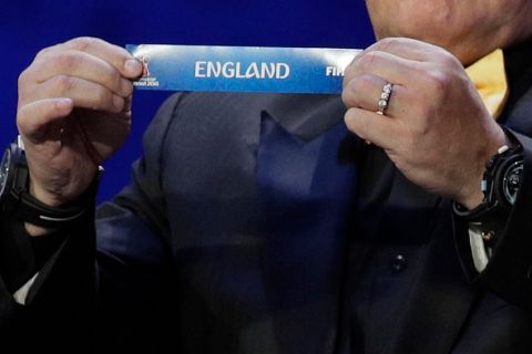 Argentine soccer legend Diego Maradona holds up the team name of England during the 2018 soccer World Cup draw in the Kremlin in Moscow, Friday, Dec. 1, 2017. (AP Photo/Dmitri Lovetsky)