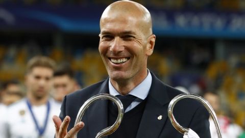 Real Madrid coach Zinedine Zidane celebrates with the trophy after winning the Champions League Final soccer match between Real Madrid and Liverpool at the Olimpiyskiy Stadium in Kiev, Ukraine, Saturday, May 26, 2018. (AP Photo/Matthias Schrader)