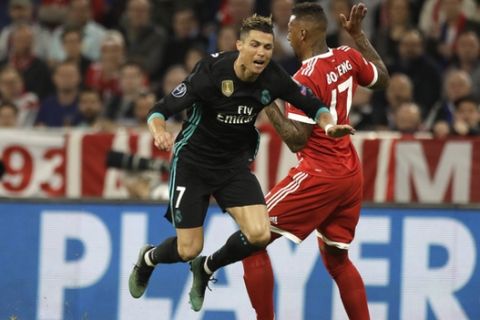 Real Madrid's Cristiano Ronaldo is airborne beside Bayern's Jerome Boateng during the semifinal first leg soccer match between FC Bayern Munich and Real Madrid at the Allianz Arena stadium in Munich, Germany, Wednesday, April 25, 2018. (AP Photo/Matthias Schrader)