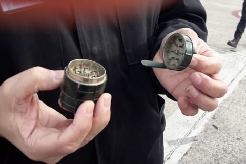 In this photo released by Argentina's Airport Police, an officer holds a pot grinder made in the shape of a grenade, which triggered an evacuation of the Astor Piazzolla airport in Mar del Plata, Argentina, Tuesday, July 17, 2018. The head of Argentina's national airport police Alejandro Itzcovich said the grenade-shaped object found at the airport was actually used to break pot into smaller pieces for smoking. (Argentina Airport Police via AP)