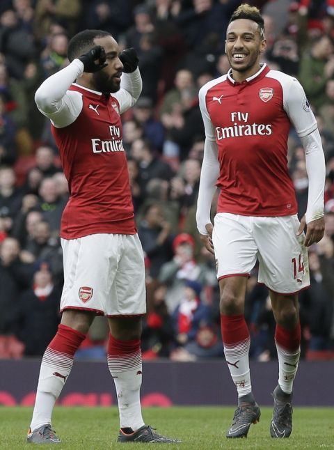 Arsenal's Alexandre Lacazette, left, celebrates after scoring a penalty, with teammate Pierre-Emerick Aubameyang during the English Premier League soccer match between Arsenal and Stoke City at the Emirates Stadium in London, Sunday, April 1, 2018. (AP Photo/Tim Ireland)