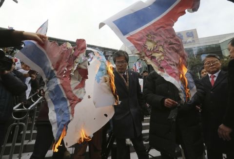 South Korean protesters burn a North Korean and Unification flag during a rally against a visit of North Korean Hyon Song Wol, head of a North Korean art troupe, in front of Seoul Railway Station in Seoul, South Korea, Monday, Jan. 22, 2018. The head of a hugely popular North Korean girl band crossed the heavily fortified border into South Korea on Sunday as part of an official delegation, triggering a media frenzy as she checked potential venues for performances during next month's Winter Olympics. (AP Photo/Ahn Young-joon)