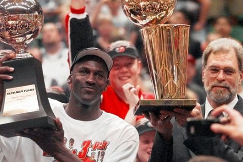 Chicago Bulls' Michael Jordan, left, holds the Most Valuable Player trophy as coach Phil Jackson holds the NBA Championship trophy after the Bulls defeated the Utah Jazz 87-86 in Game 6 of the NBA Finals in Salt Lake City, Sunday, June 14, 1998. (AP Photo/Jack Smith)