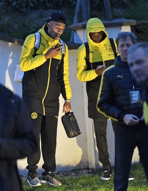 Dortmund players check their smartphones outside the team bus after it was damaged in an explosion before the Champions League quarterfinal soccer match between Borussia Dortmund and AS Monaco in Dortmund, western Germany, Tuesday, April 11, 2017.  (AP Photo/Martin Meissner)