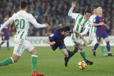 Barcelona's Sergi Roberto, left, and Betis' Guardado, right, fight for the ball during the La Liga soccer match between Barcelona and Betis at the Villamarin stadium, in Seville, Spain on Sunday, Jan. 21, 2018. (AP Photo/Miguel Morenatti)
