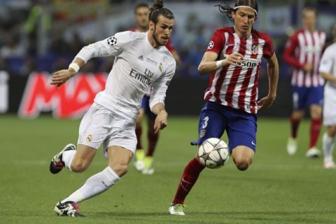 Real Madrid's Gareth Bale, left, and Atletico's Filipe Luis go for the ball during the Champions League final soccer match between Real Madrid and Atletico Madrid at the San Siro stadium in Milan, Italy, Saturday, May 28, 2016.  (AP Photo/Luca Bruno)