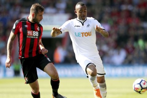 Swansea City's Jordan Ayew, right, and AFC Bournemouth's Steve Cook in action during the English Premier League soccer match at the Vitality Stadium in Bournemouth, England, Saturday May 5, 2018. (Andrew Matthews/PA via AP)